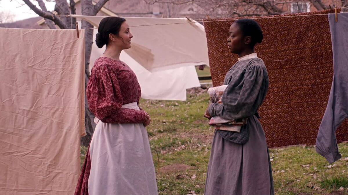 Emma and Jane talk outside while doing laundry.