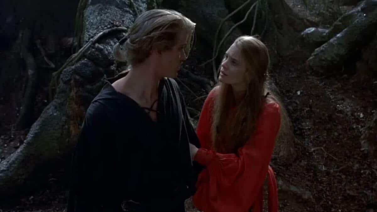 The Princess Bride screenshot of Westley and Buttercup. She wears a red dress. He's in black.