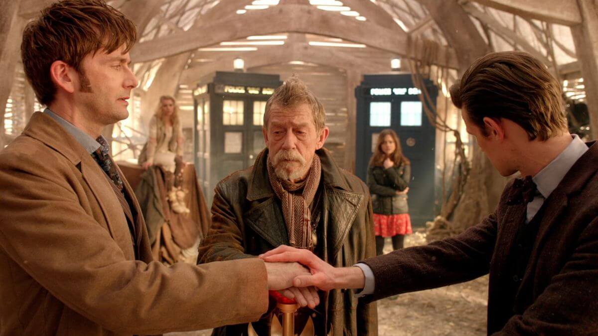 Three doctors in day of the doctor touching the red button